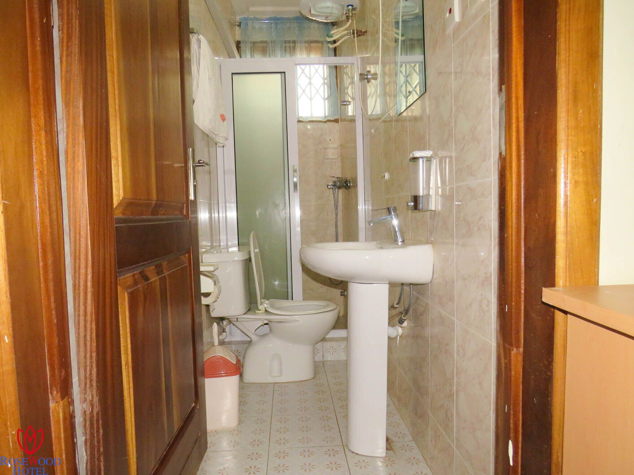 A bathroom with a toilet, sink, and shower.
