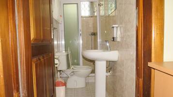 A bathroom with a toilet, sink, and shower.