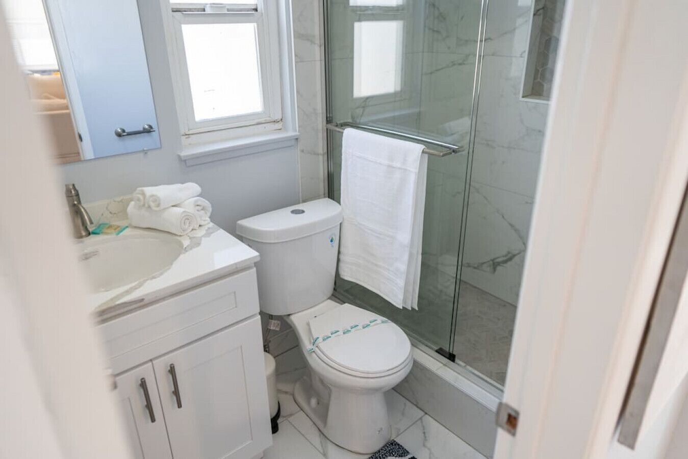 A bathroom with a toilet, sink, and shower.