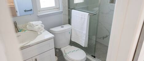 A bathroom with a toilet, sink, and shower.