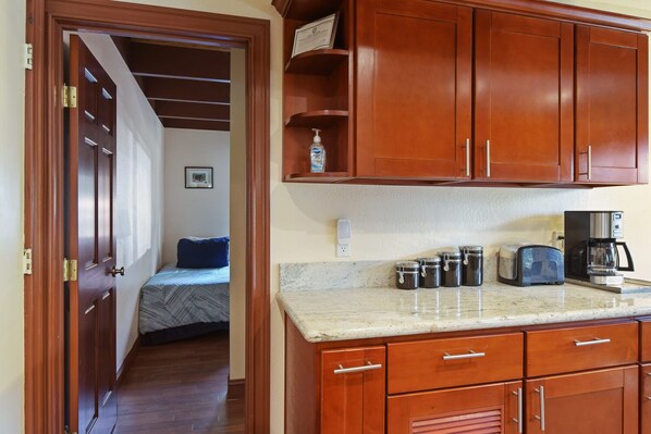 A kitchen with wooden cabinets, a countertop, a toaster, a coffee maker, and jars. - Tahoe City Getaway Minutes From Lake and Activities (Tahoe City)