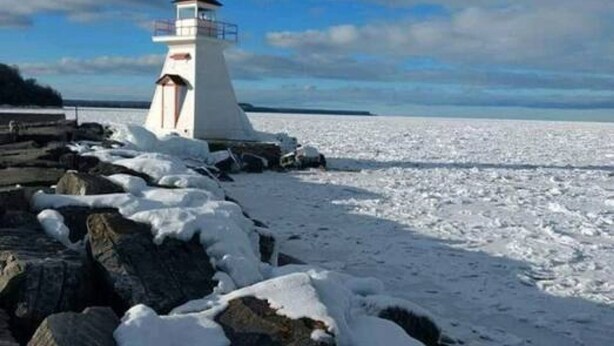 A lighthouse on a rocky shore with snow-covered rocks and a clear sky. - Family Friendly Cottage Walking Distance to Lions Head Beach (Northern Bruce Peninsula)