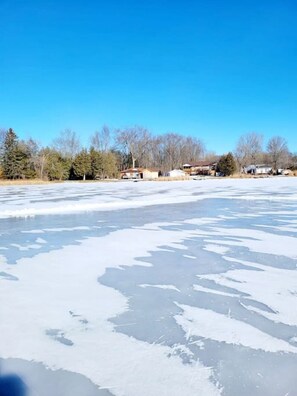 A frozen lake with houses in the background. - Chemong Lake Cottage w Private Boat Launch (Selwyn)