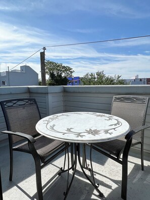 A round table with chairs on a balcony. - Zen Vibes Townhouse with Rooftop Deck Skyline View (Philadelphia)