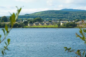 A lakeside view of a town with houses and a church. - Holiday Home With View of Kenmare Bay Estuary (Kenmare)