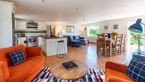 Een ruime woonkamer met keuken, eethoek en zithoek.