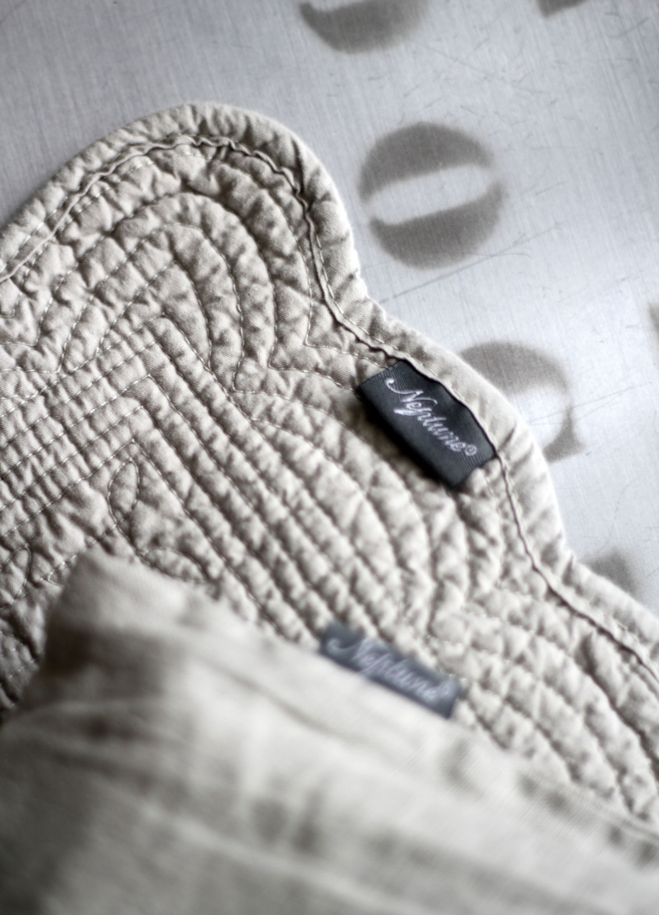 A close-up of a quilted fabric with a visible brand label.