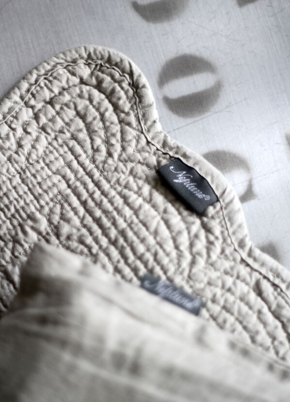 A close-up of a quilted fabric with a visible brand label.