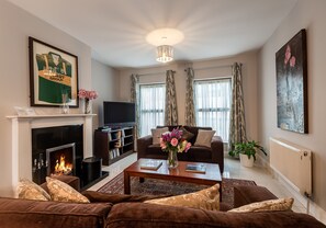 A living room with a fireplace, a sofa set, a coffee table, and a television. - 3 Bedroom pet Friendly Home With Access to Pool (Kenmare)