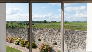 A stone wall with a brick pathway and flower beds. - 8 Bedroomed House Steeped in History (Ennis)