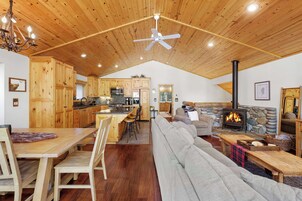 Un amplio salón con un sofá grande, una mesa de comedor de madera y una chimenea.