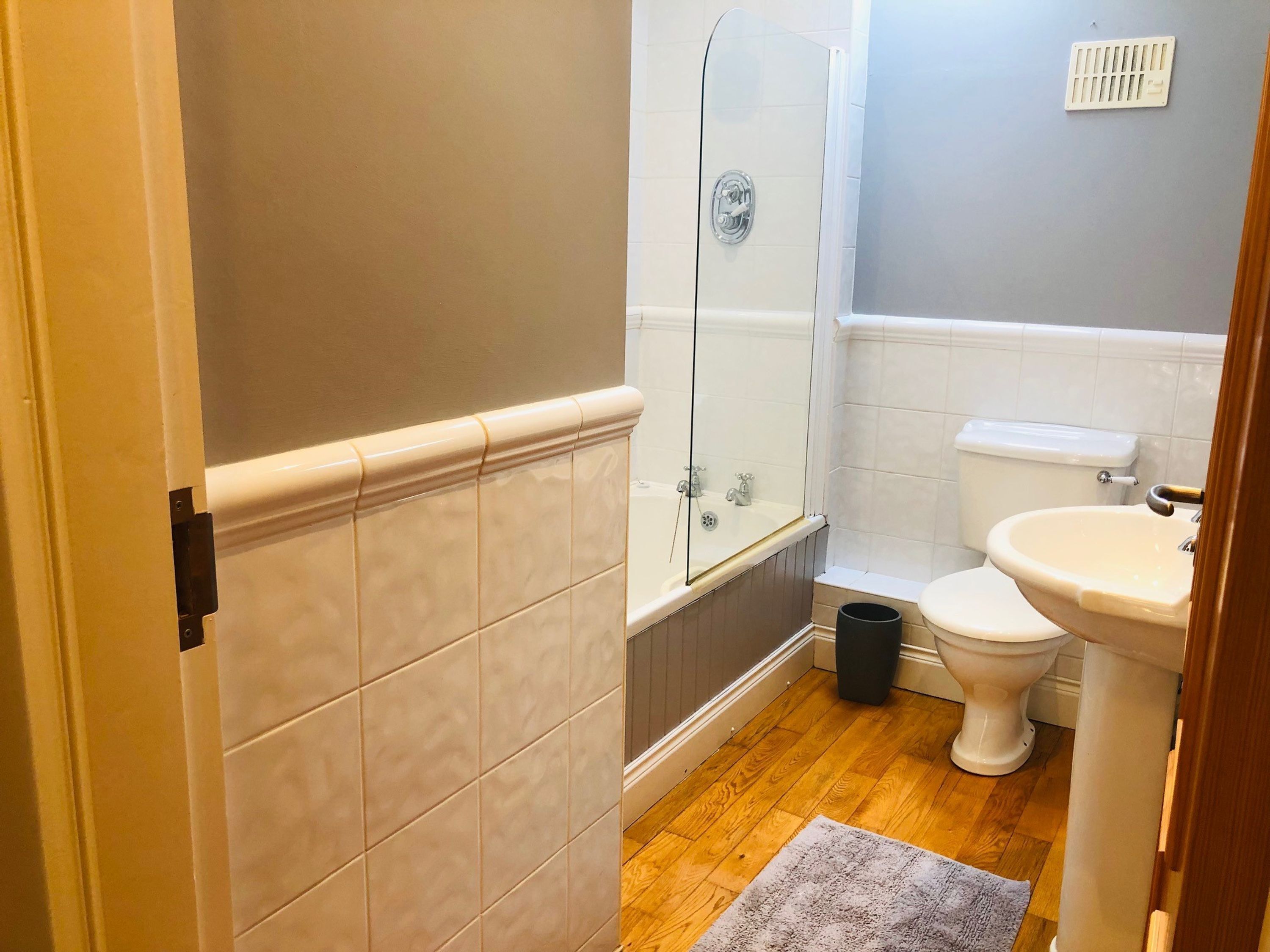 A bathroom with a bathtub, toilet, and sink.
