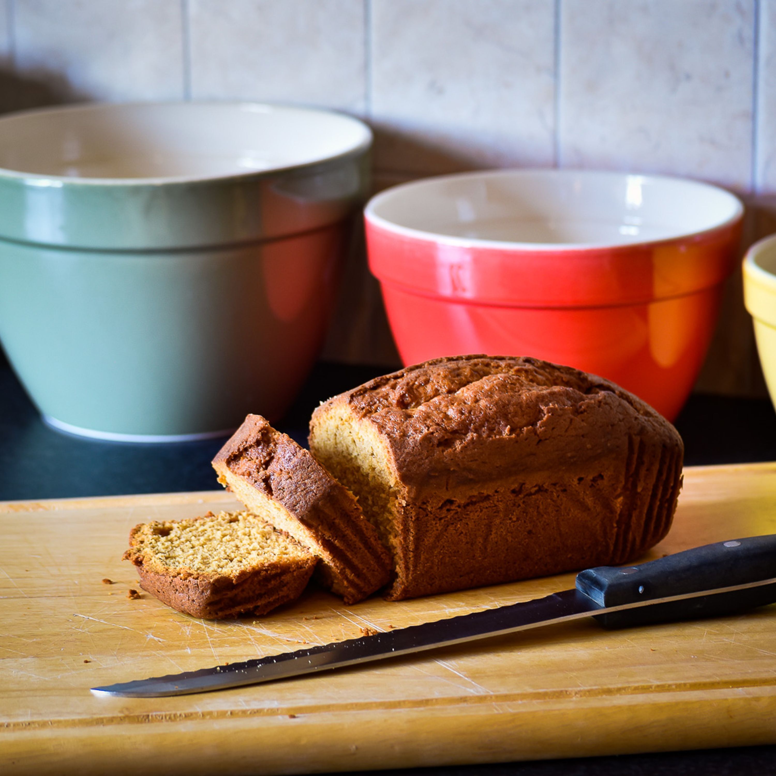 Ein Brot auf einem Holzschneidebrett mit einem Messer daneben.