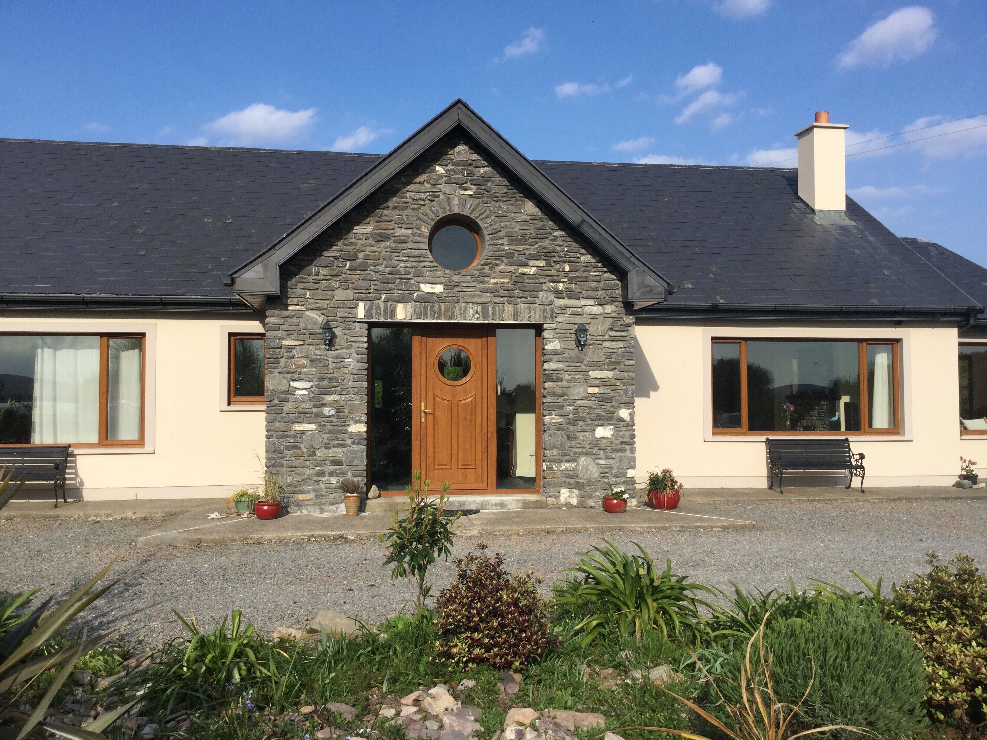 A house with a stone facade, a wooden front door, and a chimney.