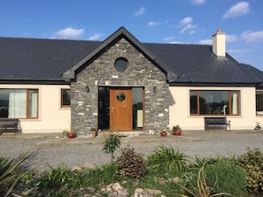 A house with a stone facade, a wooden front door, and a chimney. - 3 Bedroom Home 15 Mins Drive From Kenmare Town (Dawros)