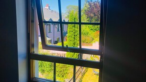 A window with a view of a residential area, including houses and greenery.