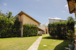 A pathway leading to a building with a tiled roof and a covered entrance. - Pousada Sandbeach (Trairi)