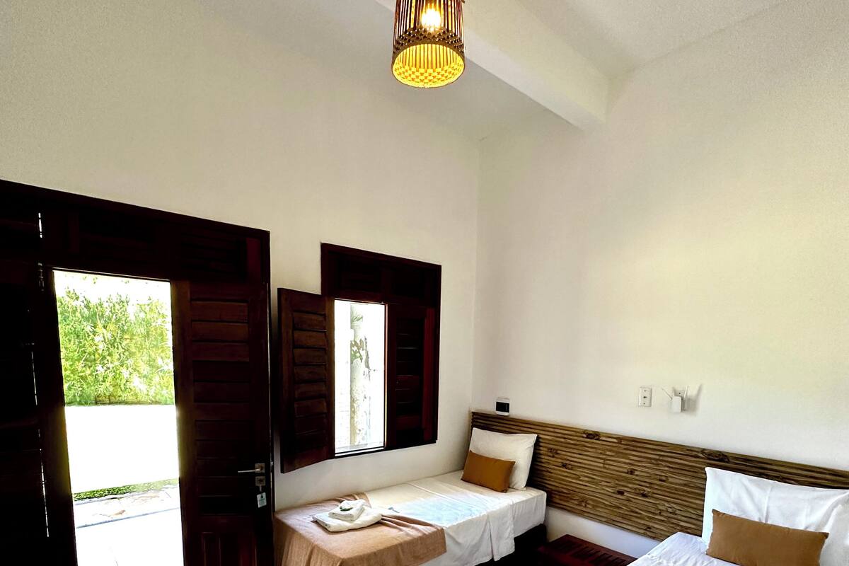 Ein Hotelzimmer mit zwei Betten, einer Sitzecke und Blick ins Freie.
