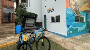 A building with a reception area, a mural, and two bicycles parked outside. - Pousada Sandbeach (Trairi)