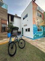 A building with a reception area, a mural, and two bicycles parked outside.