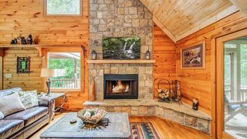 Chalet rustique, Plusieurs lits, baignoire à remous, vue sur la montagne (Bear Track Falls) | Aire de séjour | Téléviseur à écran plat de 50 po avec télévision numérique, foyer