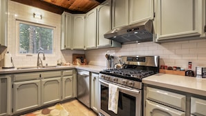 A modern kitchen with light grey cabinets, a stainless steel stove, and a window providing natural light. - Christmas Valley Chalet Tahoe Adventure Awaits! (South Lake Tahoe)