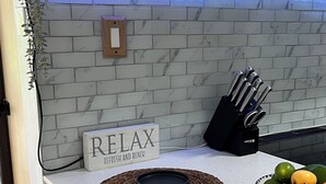 A kitchen counter with a white marble backsplash, a sign that says "RELAX REFRESH AND RENEW", and a bowl of fruit. - Tropical Beachfront Villa (Río Grande)