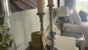 A room with a bed, a lamp, a vase, and a decorative item on a table.