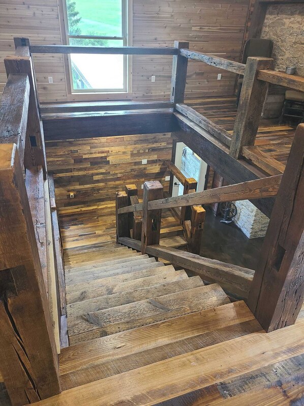 A wooden staircase with a rustic design, leading to a lower level.