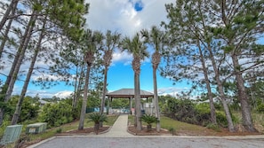 A gazebo surrounded by tall trees and a clear sky.