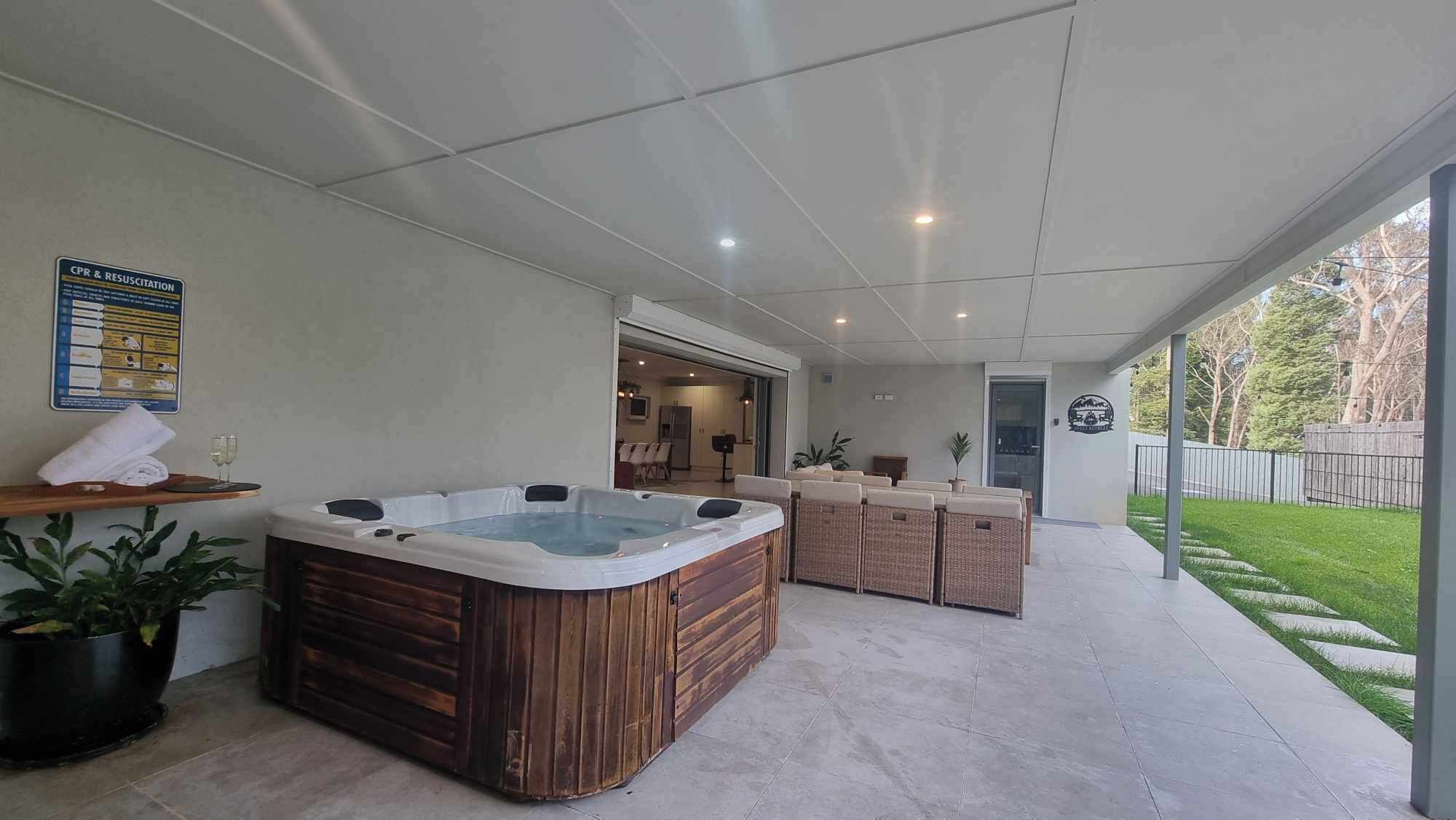 Zona de spa con un jacuzzi, asientos y un cartel de reanimación cardiopulmonar.