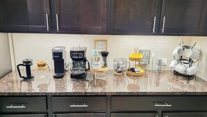 A kitchen counter with coffee makers, mugs, and a coffee machine. - Home In The Heart Of Alvin! (Alvin)