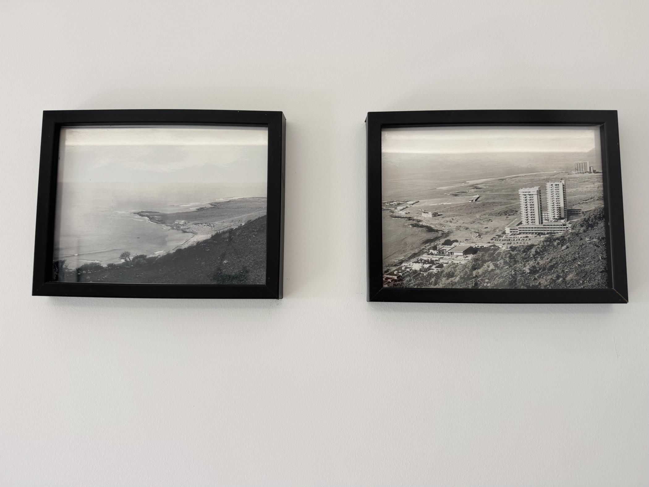 Deux photographies en noir et blanc, encadrées, représentant des paysages côtiers avec des bâtiments.