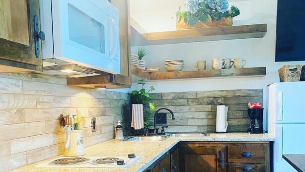 A kitchen with wooden cabinets, a granite countertop, a built-in microwave, and a coffee maker. - Cozy Lakeview Cabin, Boat Parking, Breathtaking Lake View, One Hour from Tulsa  (Afton)