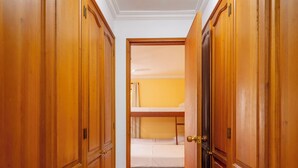 A hallway with wooden wardrobes and a bunk bed in the background.