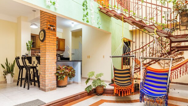 A spacious living area with a kitchen, a staircase, and a hammock.
