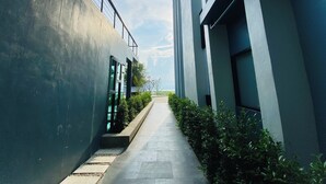 A modern building with a narrow pathway flanked by greenery and a clear sky. - ABIZZ Hotel KwanPhayao (Phayao)