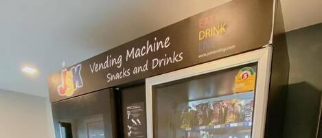 A vending machine labeled "Vending Machine Snacks and Drinks" with a "PUSH" button and a display screen.