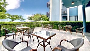 A rooftop terrace with outdoor furniture, a clear sky, and a building with balconies. - ABIZZ Hotel KwanPhayao (Phayao)