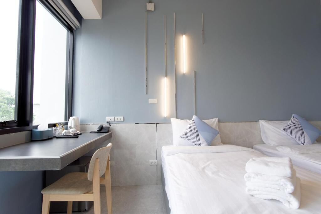 Et moderne hotelværelse med en stor seng, et skrivebord med stol og et vindue med udsigt.