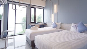 A modern hotel room with two beds, a desk, and a large window offering a view of the outdoors. - ABIZZ Hotel KwanPhayao (Phayao)