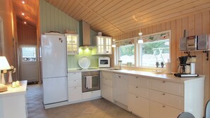 A compact kitchen with white cabinets, a built-in oven, a microwave, and a coffee maker. - "Lilia" - 900m from the sea by Interhome (Væggerløse)
