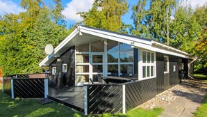 A modern cabin with a deck, large windows, and a covered outdoor seating area. - "Aimi" - 270m from the sea by Interhome (Væggerløse)