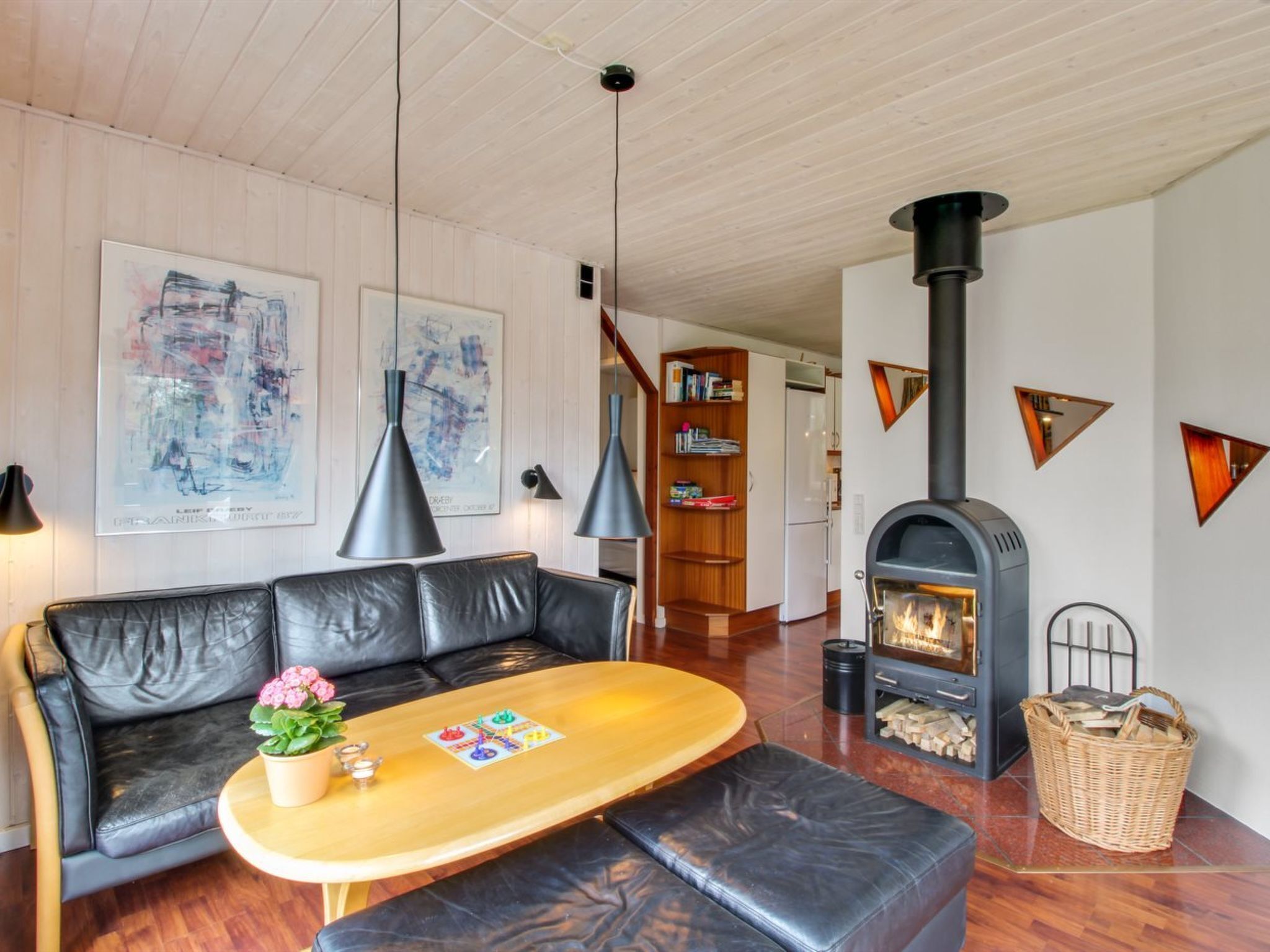 Una sala moderna con un sofá de cuero, una mesa de centro de madera y una chimenea.