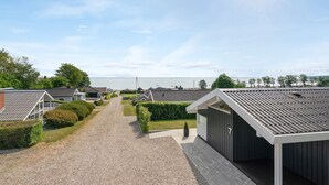 Un parc de caravanes avec des allées de gravier, des bâtiments de style caravane et une vue sur la mer.