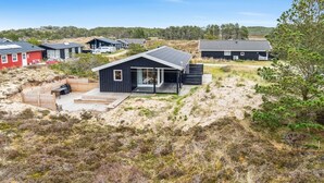 A modern house with a large deck, surrounded by dunes and sparse vegetation. - "Sulo" - 1.4km from the sea by Interhome (Thisted)