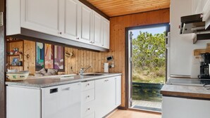 A modern kitchen with white cabinets, a granite countertop, and a wooden ceiling. - "Sulo" - 1.4km from the sea by Interhome (Thisted)