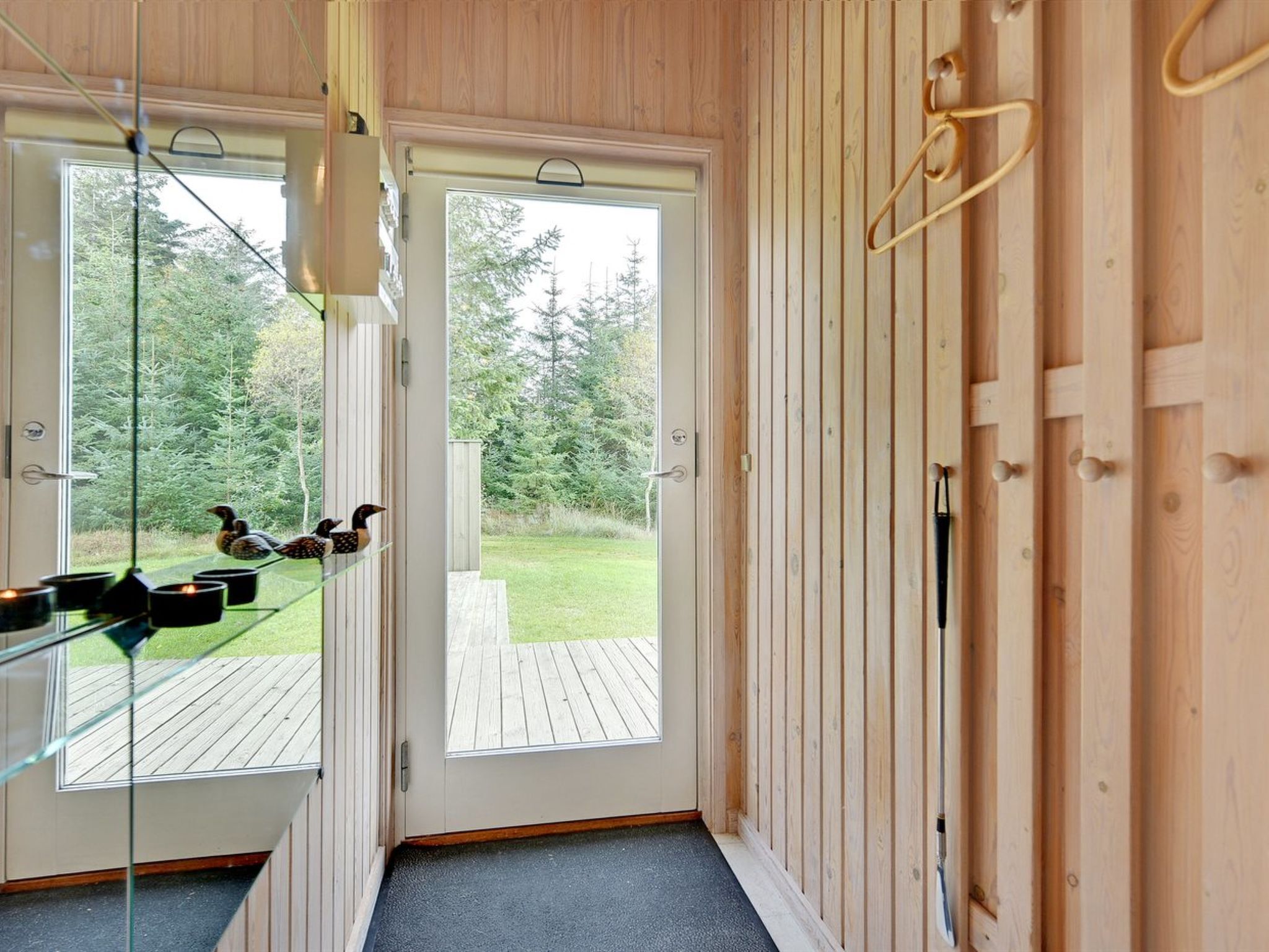 A wooden interior with a glass door leading to a deck.