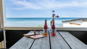 A wooden table with two bottles and a pair of sunglasses, overlooking a beach. - "Scarlet" - 5m from the sea by Interhome (Hasle)