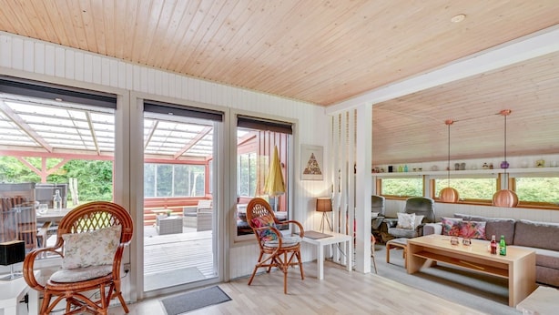 A spacious living area with a wooden ceiling, large windows, and a cozy seating arrangement including a sofa and chairs. - "Anline" - 900m to the fjord by Interhome (Tarm)